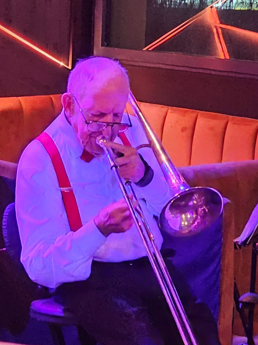François Mayer au trombone dans un club, lumière tamisée